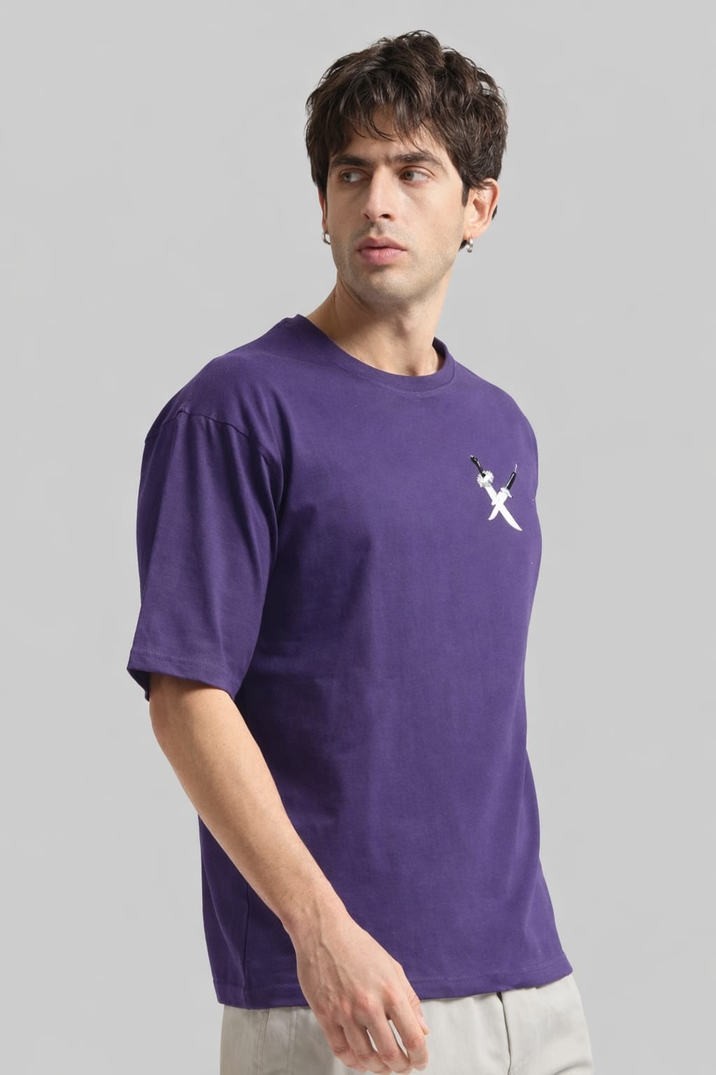 Man wearing a purple t-shirt with a logo on a gray background
