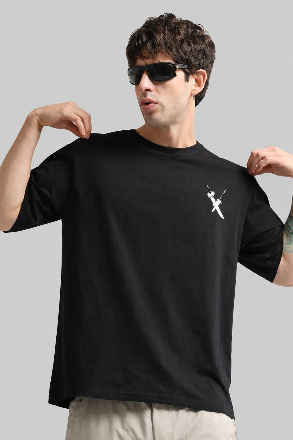 Man wearing a black t-shirt with a white logo on a gray background